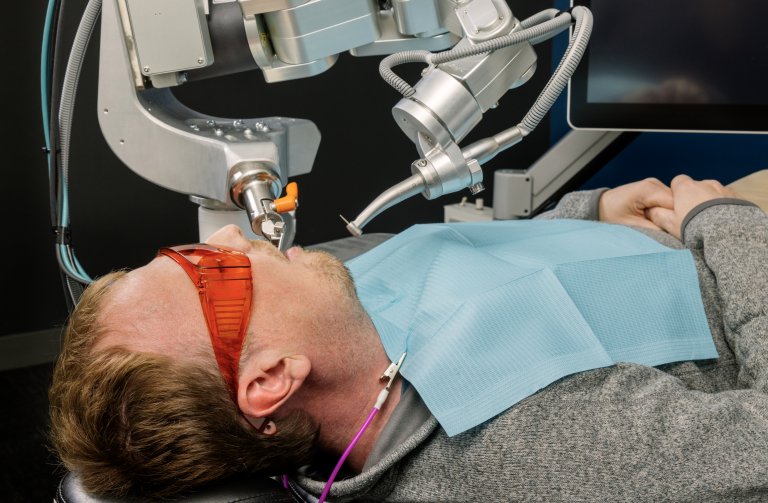 Bras de robot dentaire autonome guidé par l'IA réalisant un soin sur un patient dans un cabinet dentaire moderne