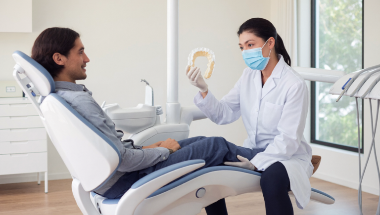 Patient en consultation dentaire découvrant une gouttière occlusale sur mesure pour traiter le bruxisme et le stress