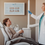 Un patient tenant une cigarette électronique discute des effets du vapotage sur sa santé bucco-dentaire avec son dentiste